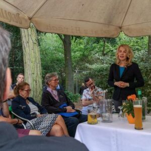 FDP Generalsekretärin Linda Teutenberg referiert in einem Garten vor einer Gruppe sitzender Zuhörer